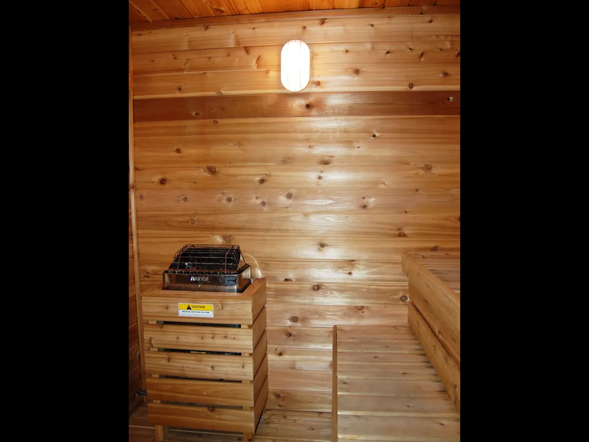 An inviting interior shot of a wooden-walled space, likely the community sauna. The warm light and tranquil mood evoke relaxation and self-care—ideal comforts for winter visitors looking to unwind indoors.